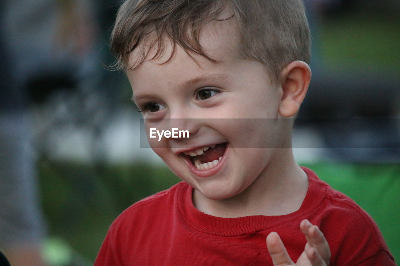 Close-up of cheerful boy standing at park