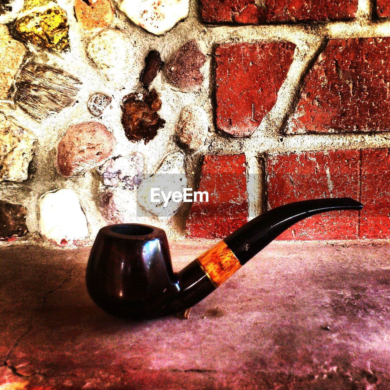 Close-up of smoking pipe on retaining wall