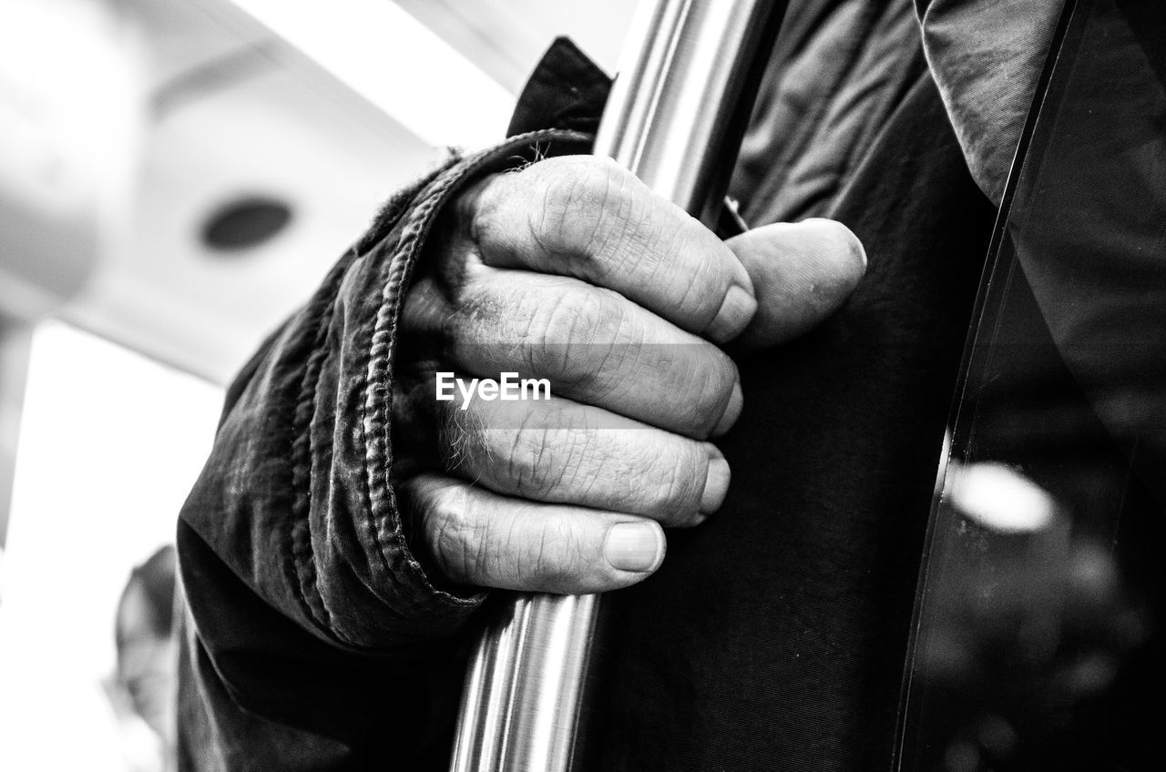 Midsection of senior man holding pole