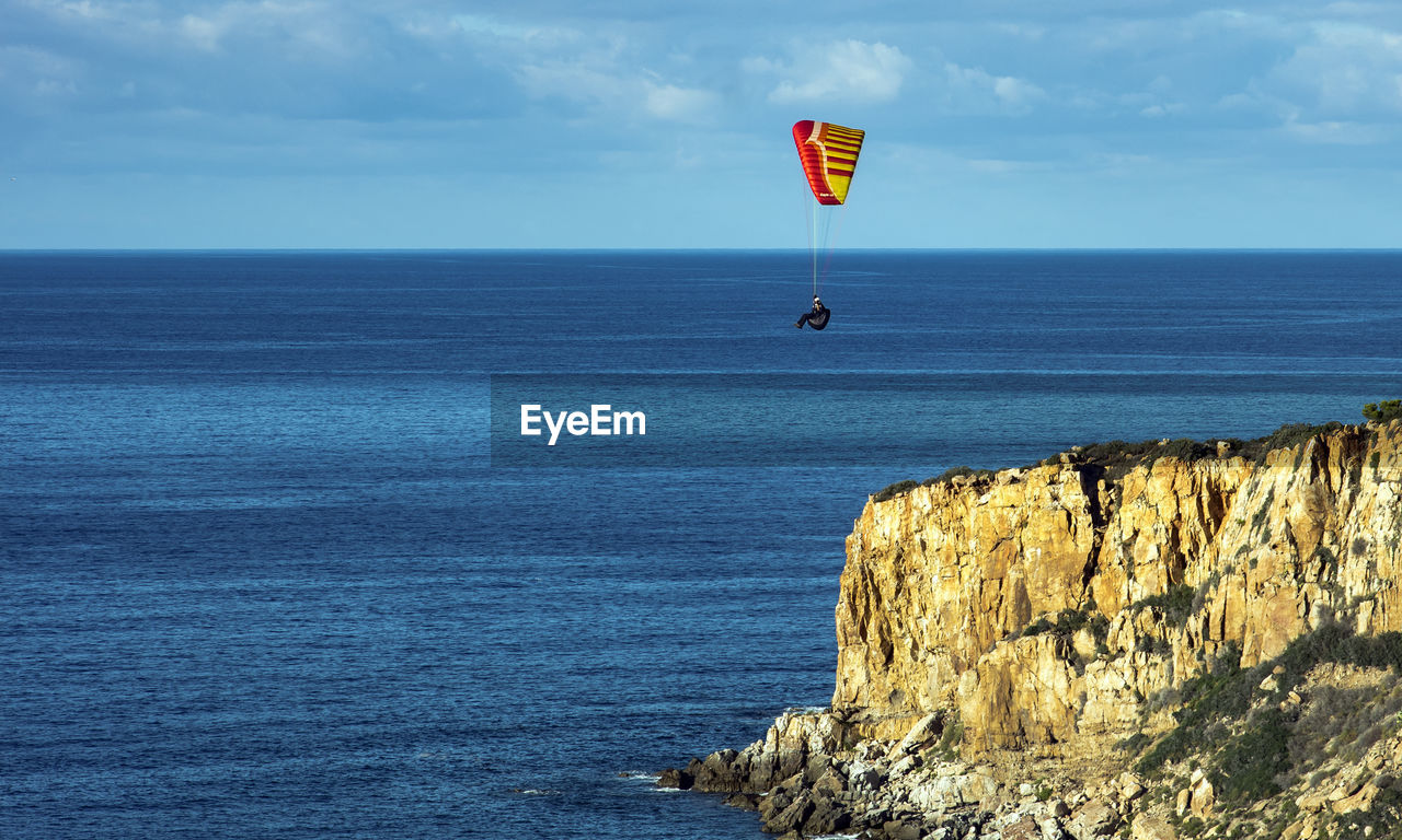 Man paragliding over sea