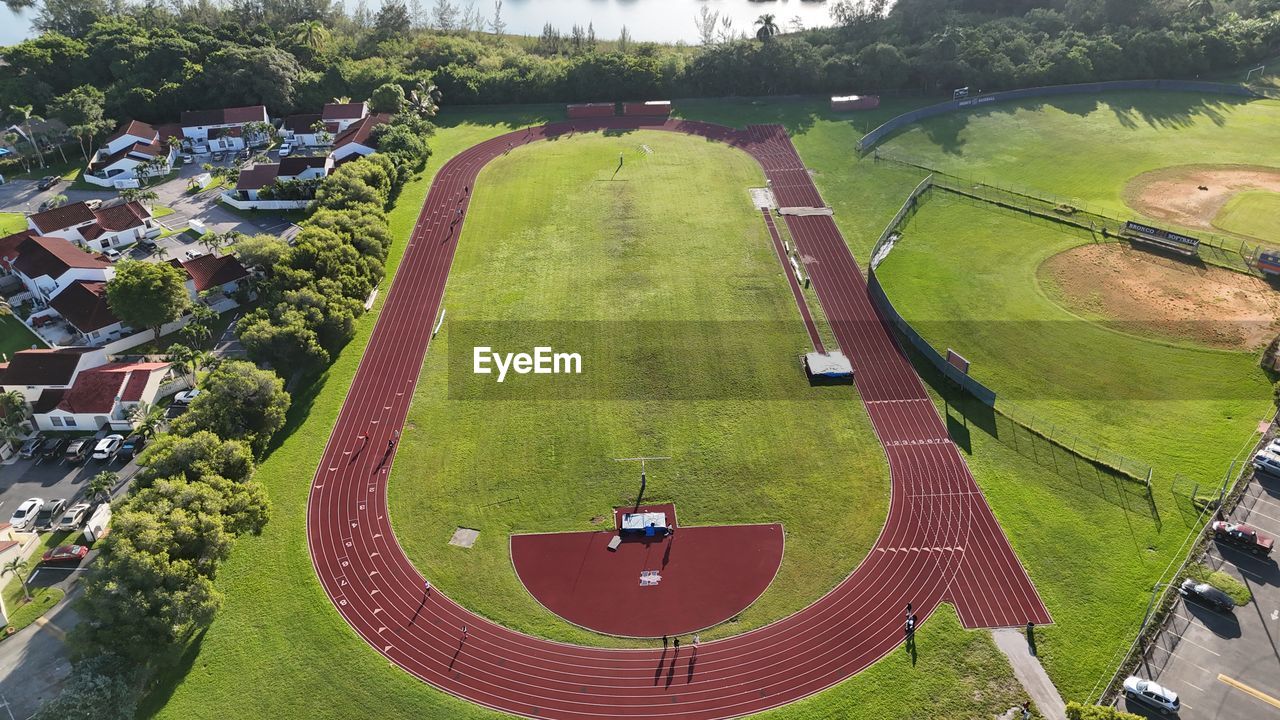 aerial photography, high angle view, plant, race track, sports, sport venue, residential area, bird's-eye view, tree, nature, green, grass, day, aerial view, stadium, outdoors, leisure activity, architecture, estate, lawn, landscape, environment, no people, transportation