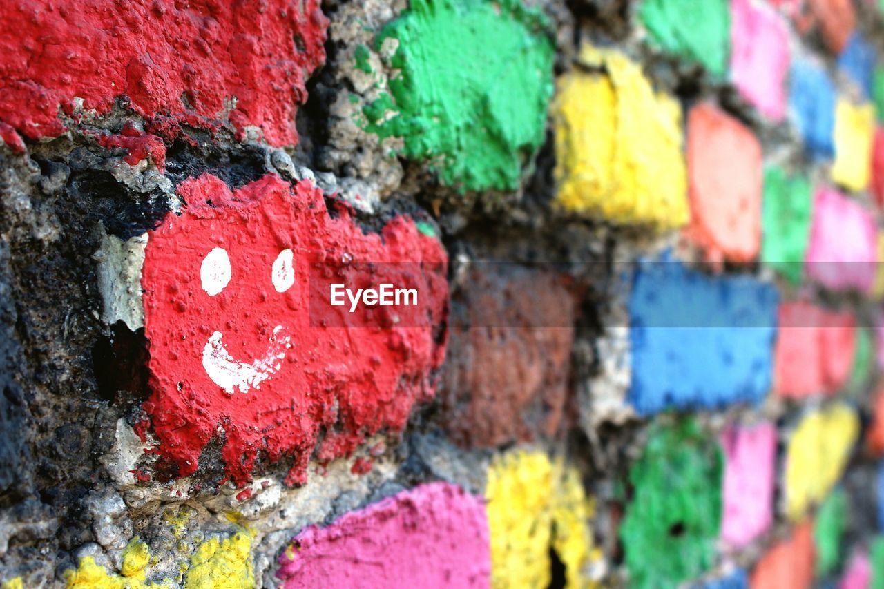 Close-up of smiley face on colorful painted wall