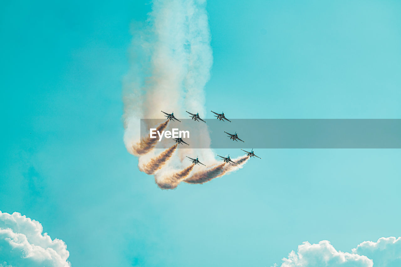 Low angle view of airshow against blue sky