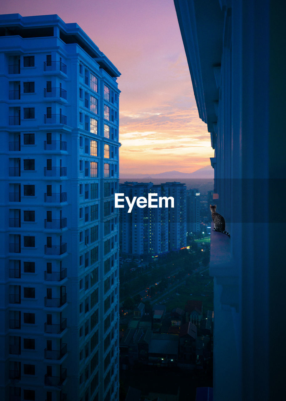 MODERN BUILDINGS AGAINST SKY DURING SUNSET