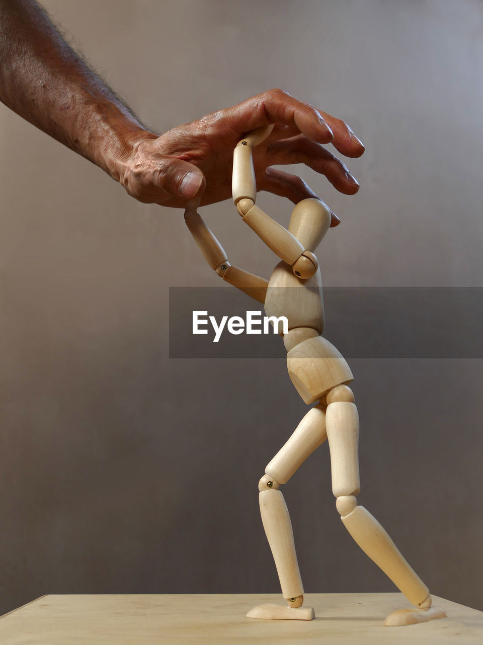 Close-up of hand over figurine on table