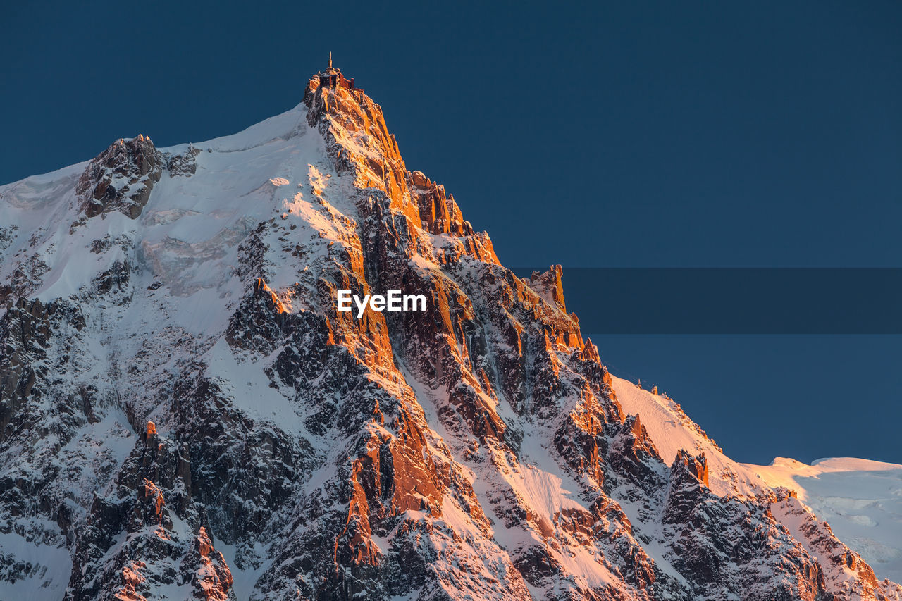 Low angle view of snowcapped mountain against sky