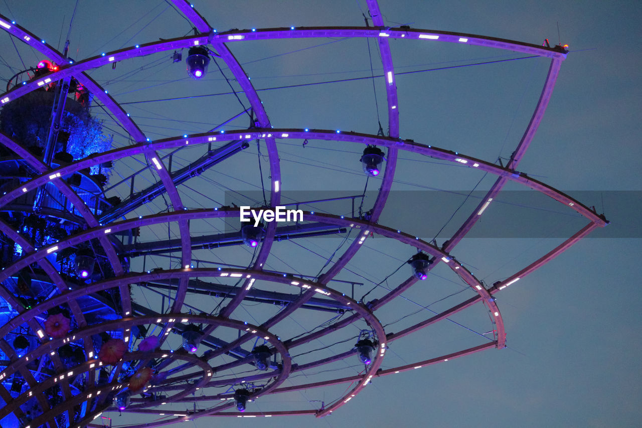 LOW ANGLE VIEW OF ILLUMINATED FERRIS WHEEL AGAINST CLEAR BLUE SKY