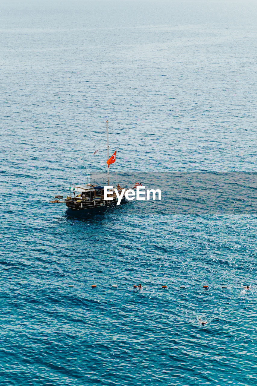 HIGH ANGLE VIEW OF BOAT ON SEA