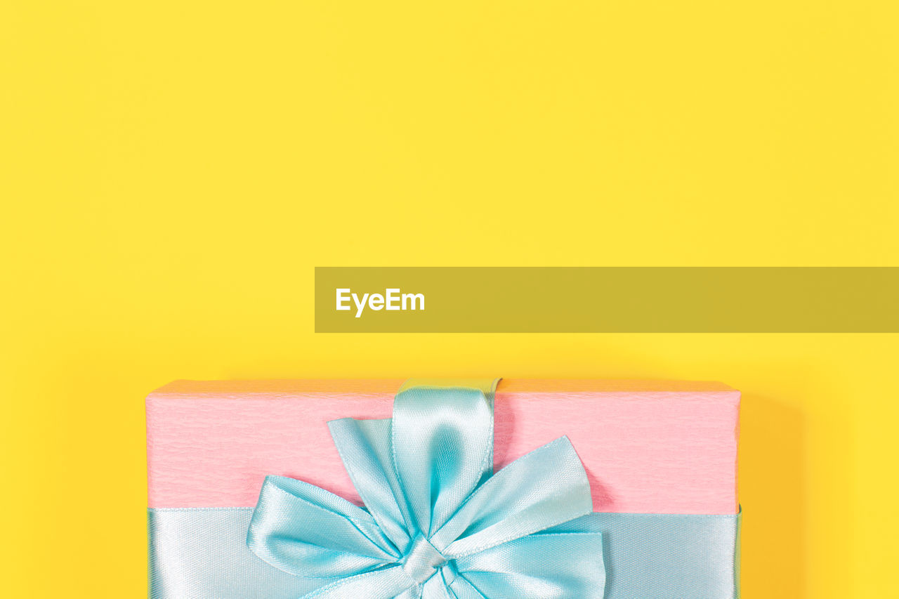 Close-up of christmas present against yellow background