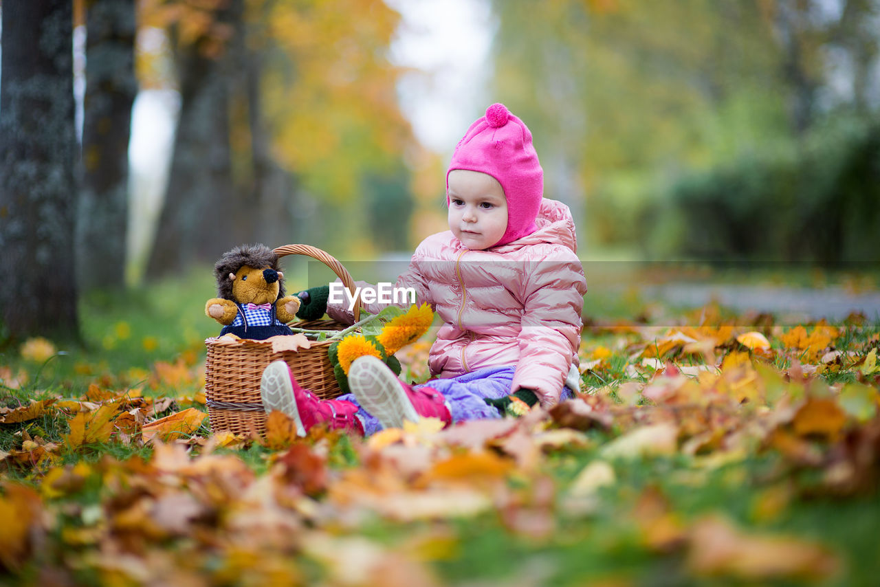 Cute baby girl sitting on field at park