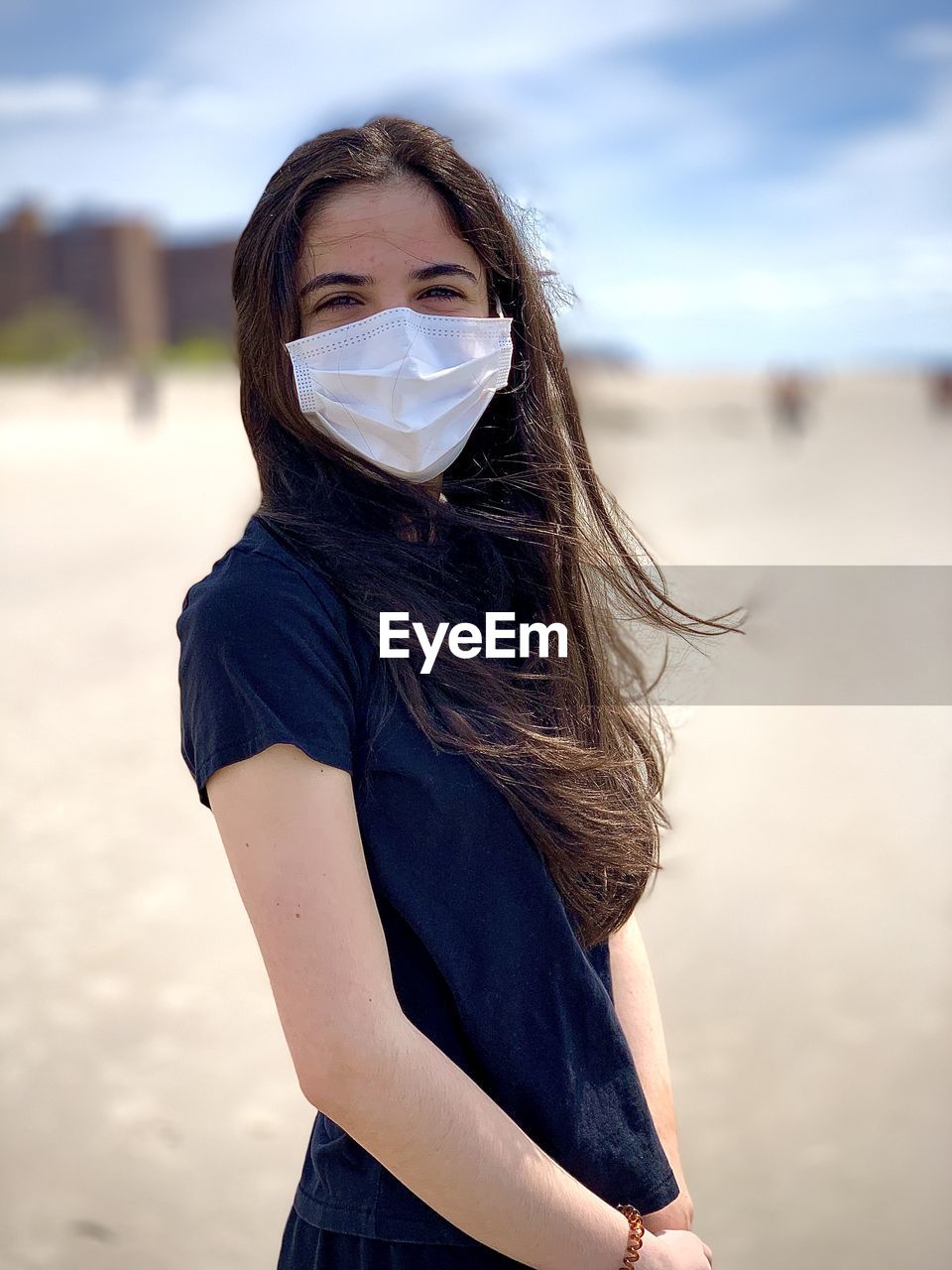 Portrait of young woman standing at beach