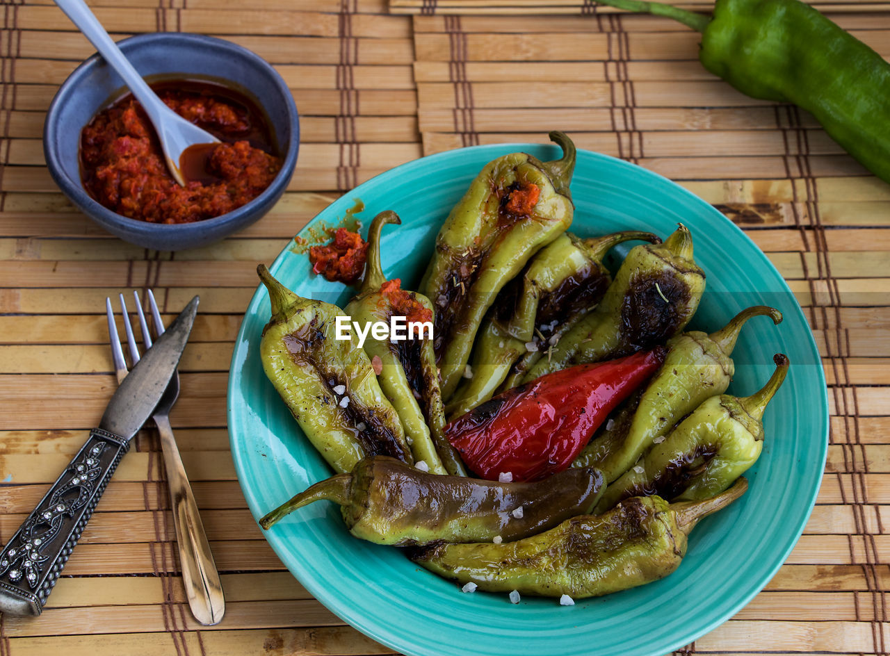 food, food and drink, vegetable, healthy eating, dish, wellbeing, freshness, produce, spice, plate, wood, no people, cuisine, kitchen utensil, fruit, pepper, high angle view, eating utensil, meal, indoors, meat, plant, barbecue, chili pepper, table