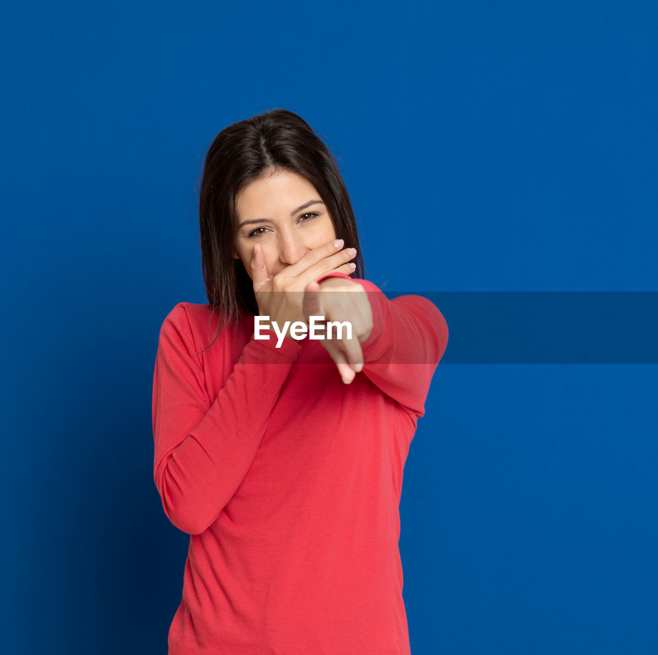 BEAUTIFUL YOUNG WOMAN AGAINST BLUE BACKGROUND