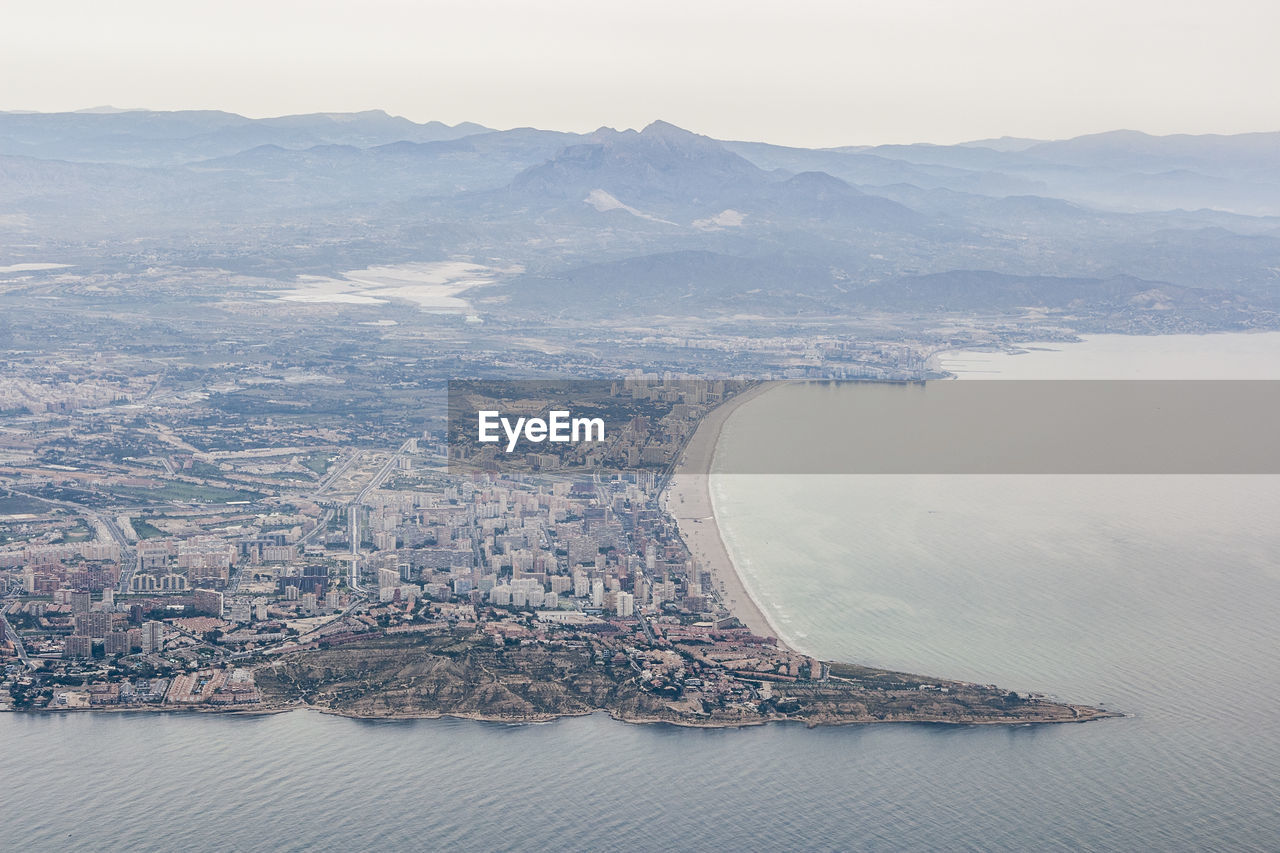 AERIAL VIEW OF BUILDINGS AND SEA AGAINST SKY