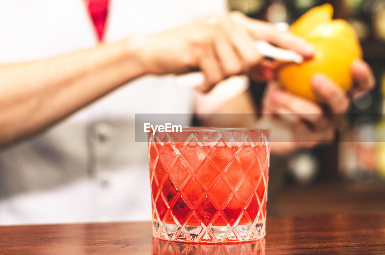 CLOSE-UP OF HAND HOLDING DRINK IN GLASS