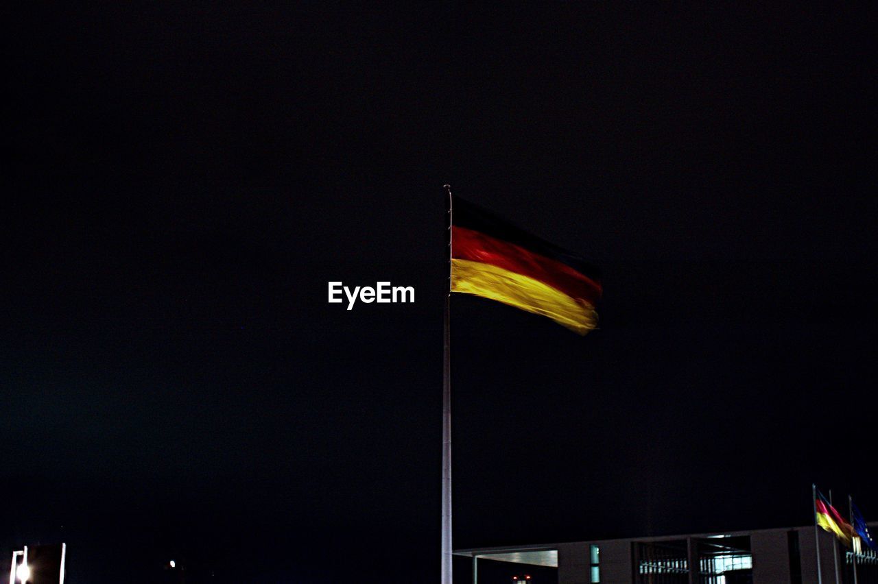Low angle view of german flag against sky at night