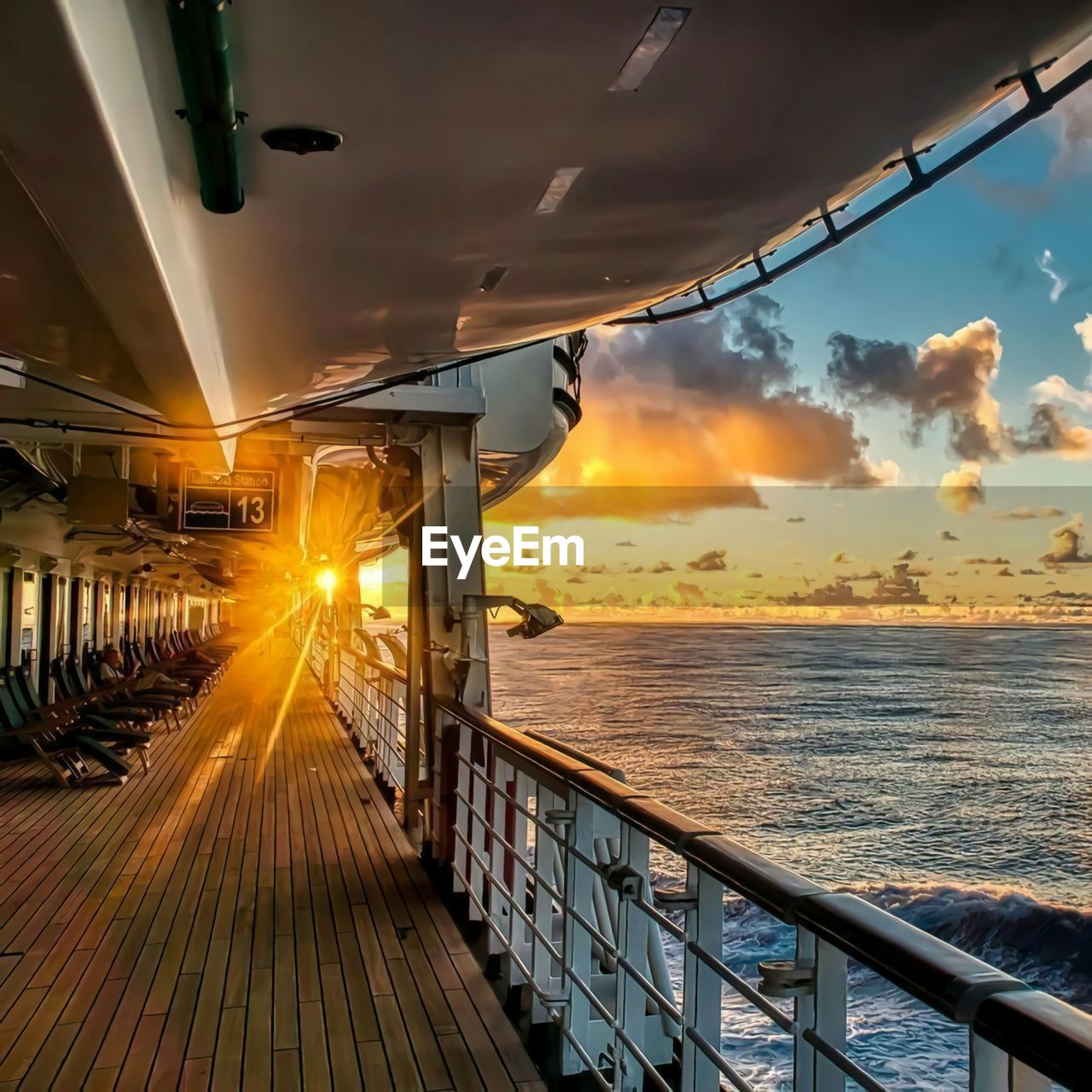 The view of the sunset seen from a cruise ship that is sailing.