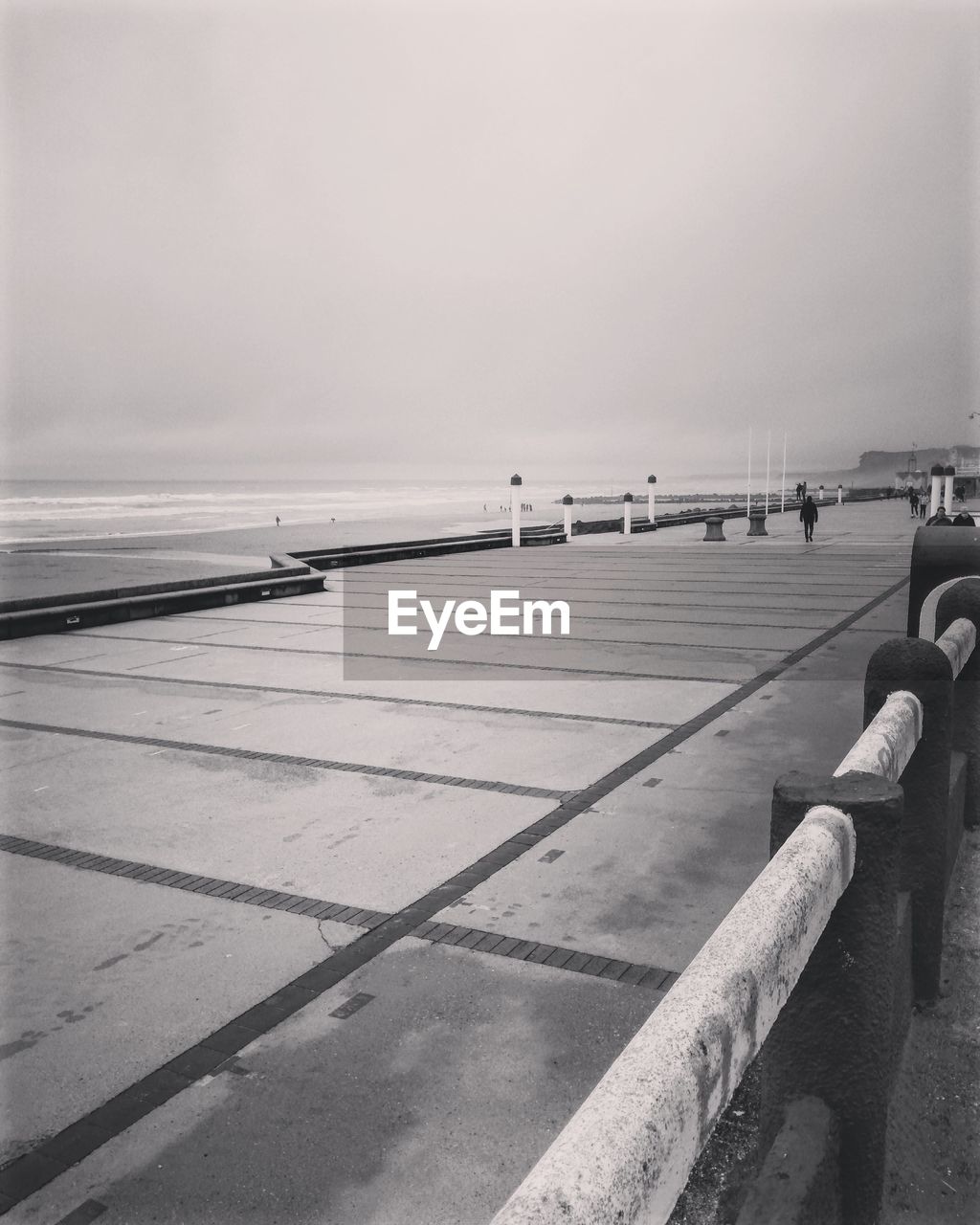 MAN ON RAILING AGAINST SEA