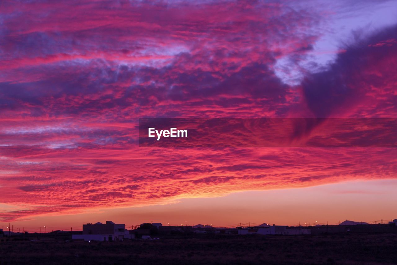 DRAMATIC SKY OVER CITY DURING SUNSET