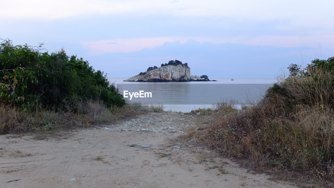 Scenic view of beach against cloudy sky