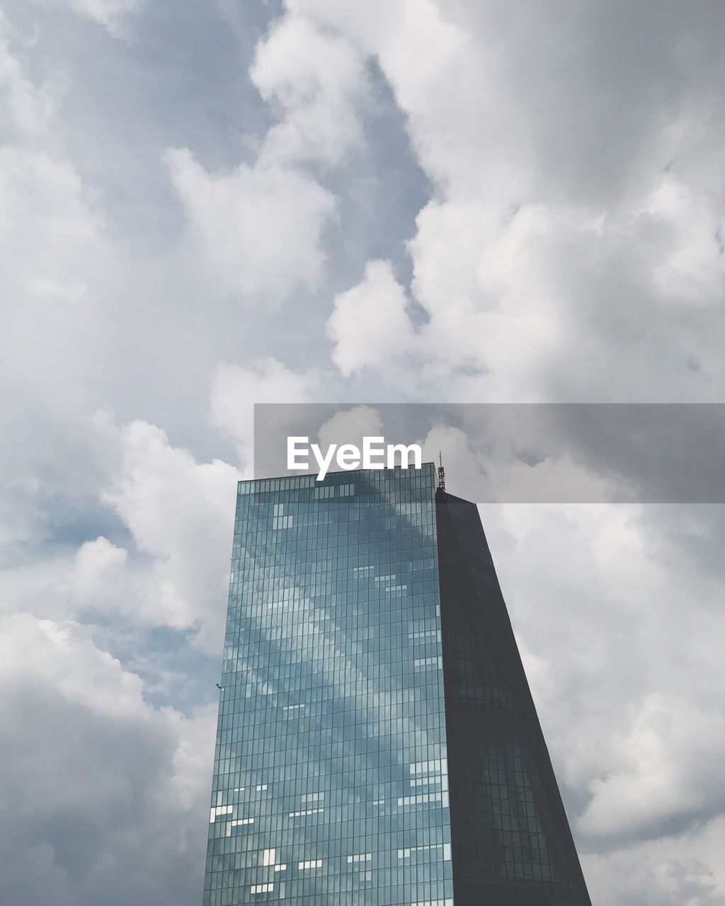 Low angle view of modern building against cloudy sky