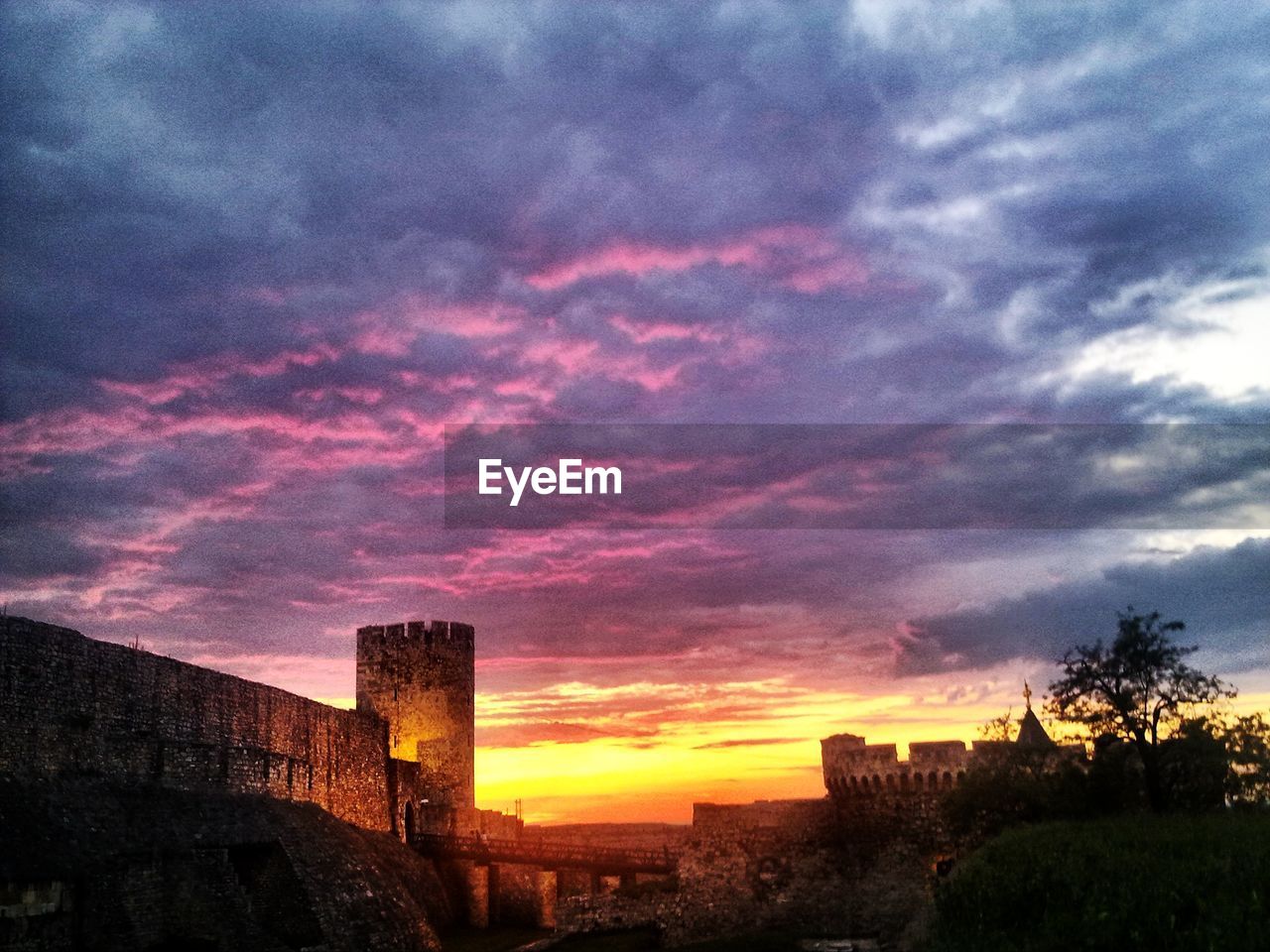 Castle against cloudy sky at sunset