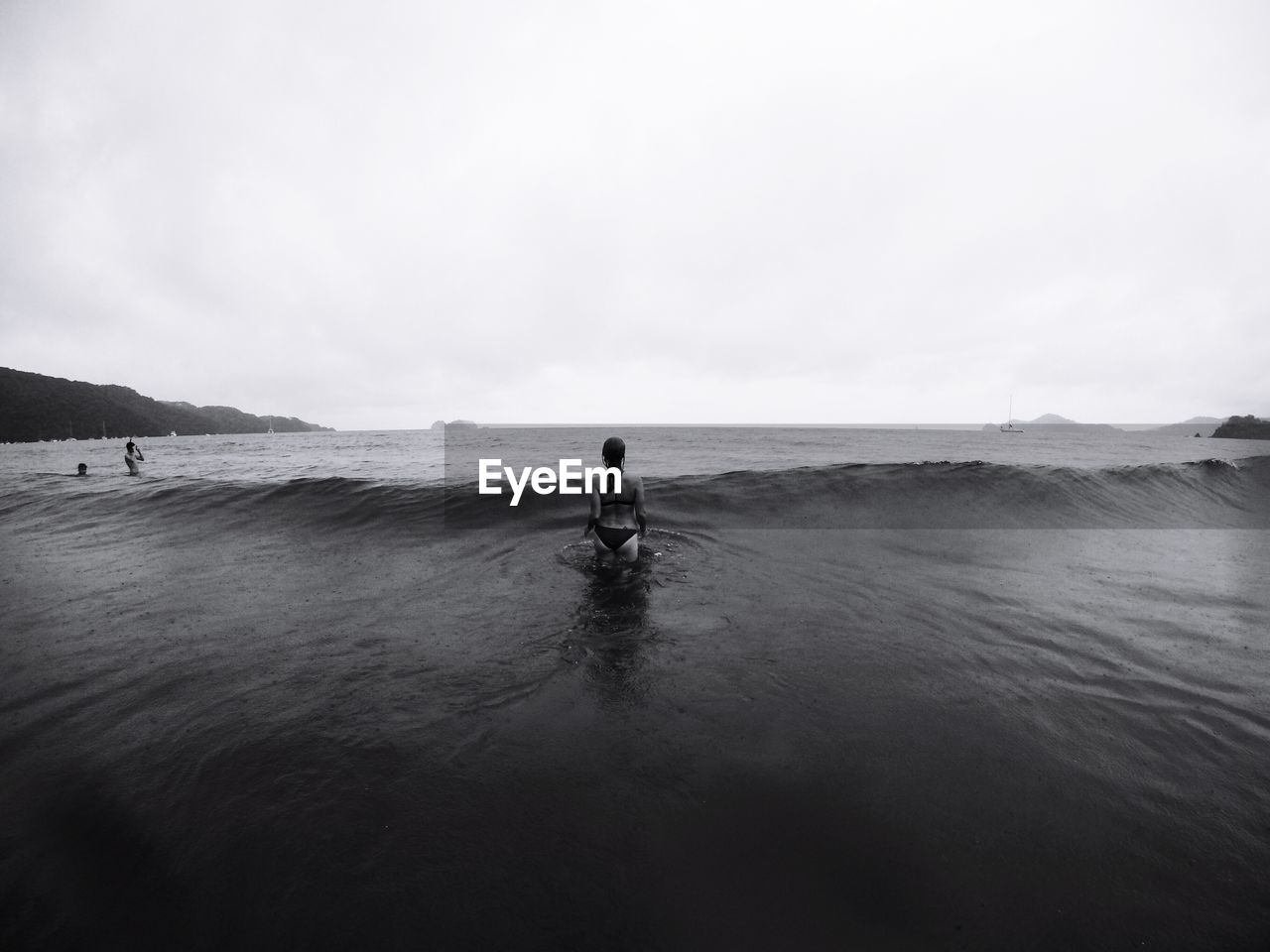 Rear view of woman in sea against sky