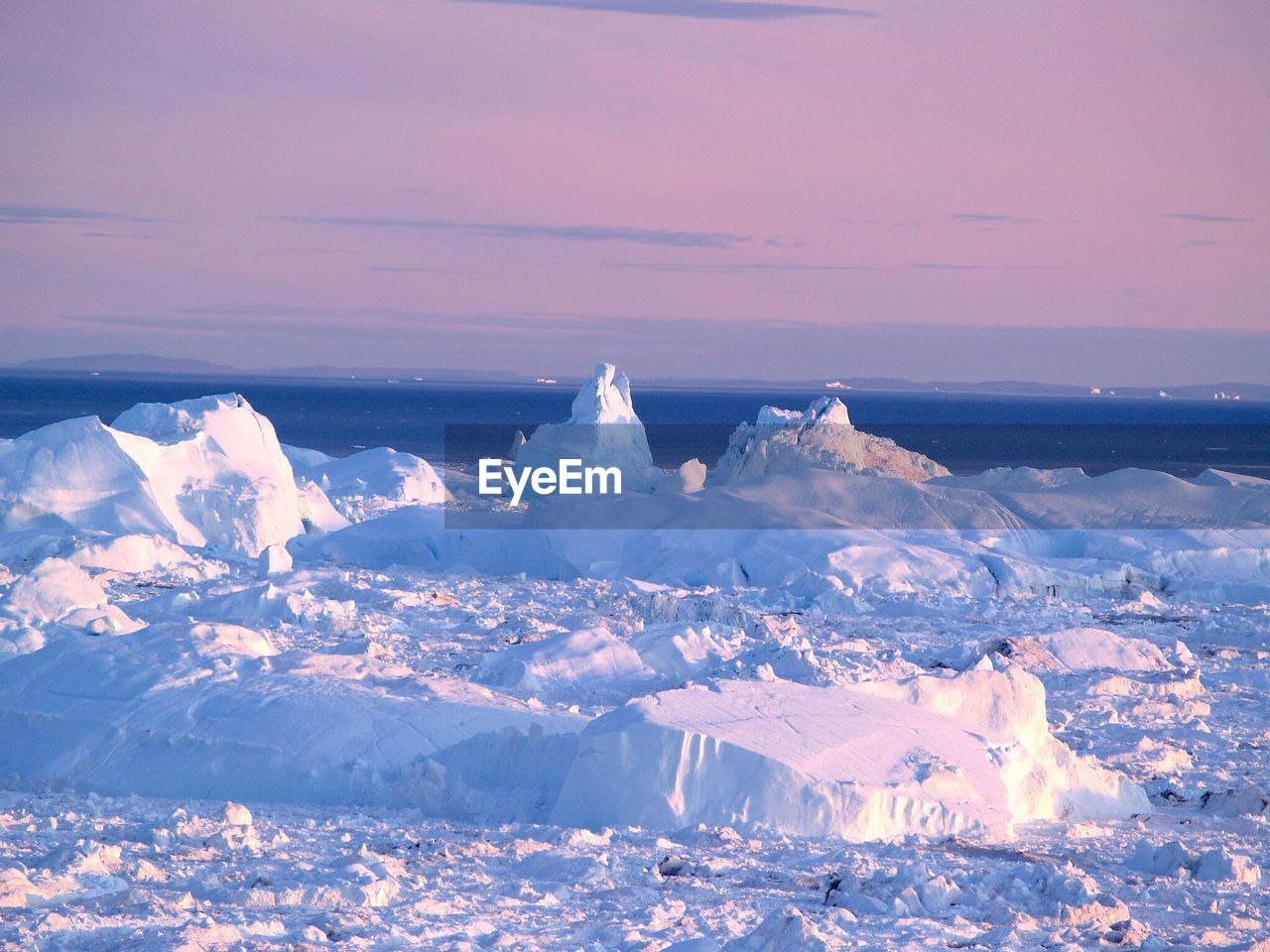 Scenic view of ice berg against sky during sunset