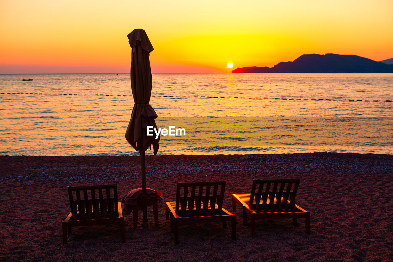 Chaise lounges and umbrella on the beach in the twilight . fantastic coastal summer vacation 