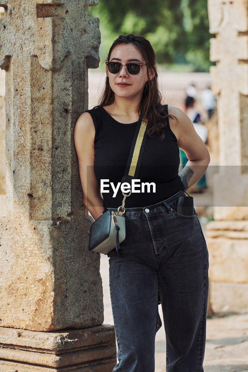 portrait of young woman standing against wall