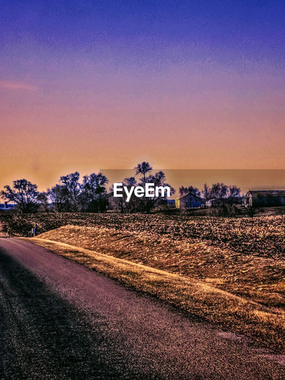 ROAD BY FIELD AGAINST CLEAR SKY AT SUNSET