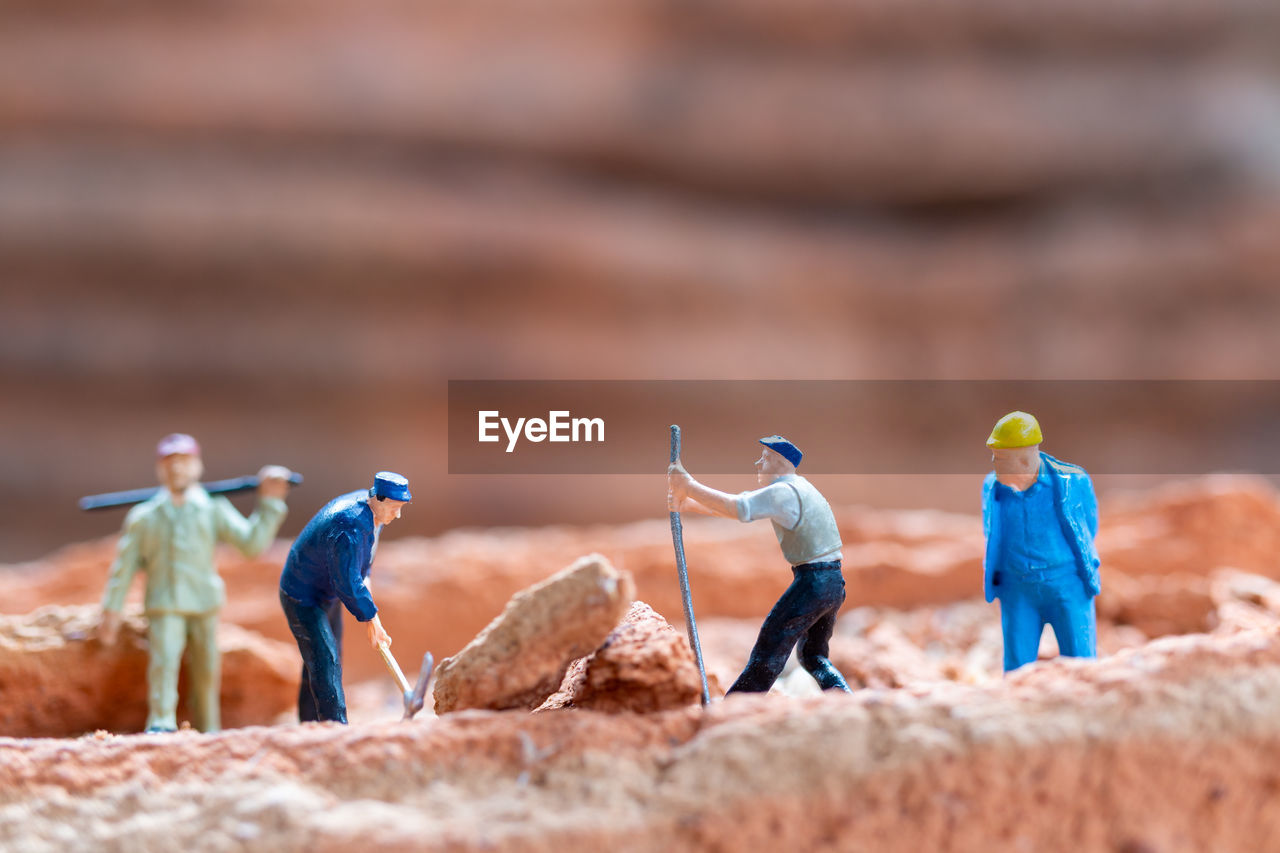 Miniature people worker team fixing bricks during the construction of a house
