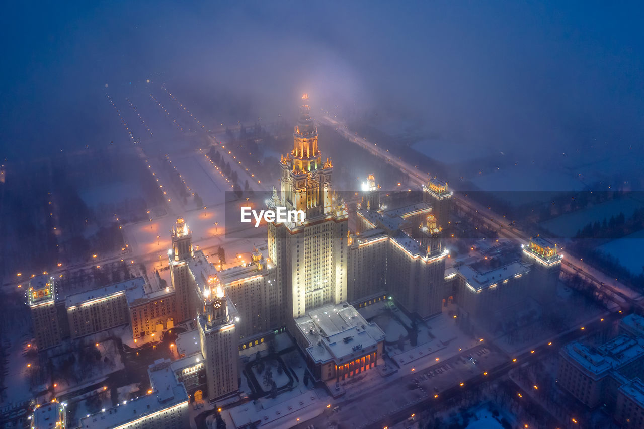 High angle view of illuminated buildings against sky at night