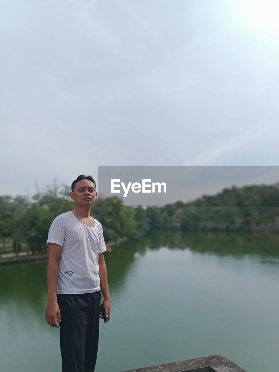 PORTRAIT OF YOUNG MAN STANDING IN LAKE