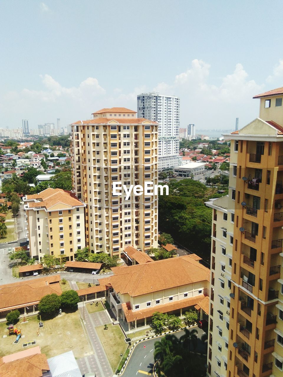 HIGH ANGLE VIEW OF BUILDINGS AND TREES AGAINST SKY