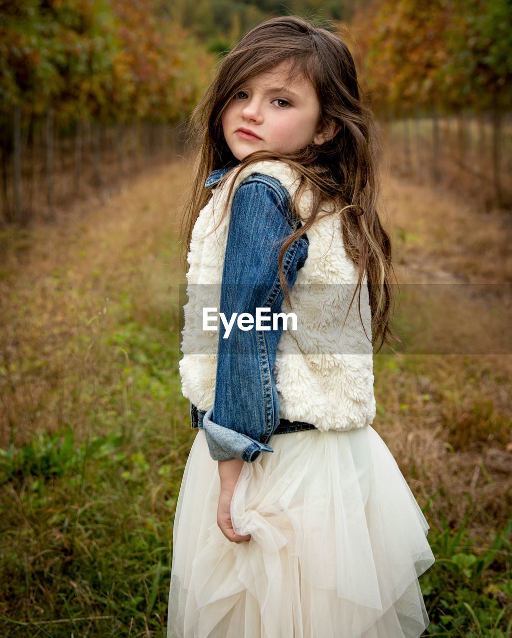 Portrait of smiling girl standing on field