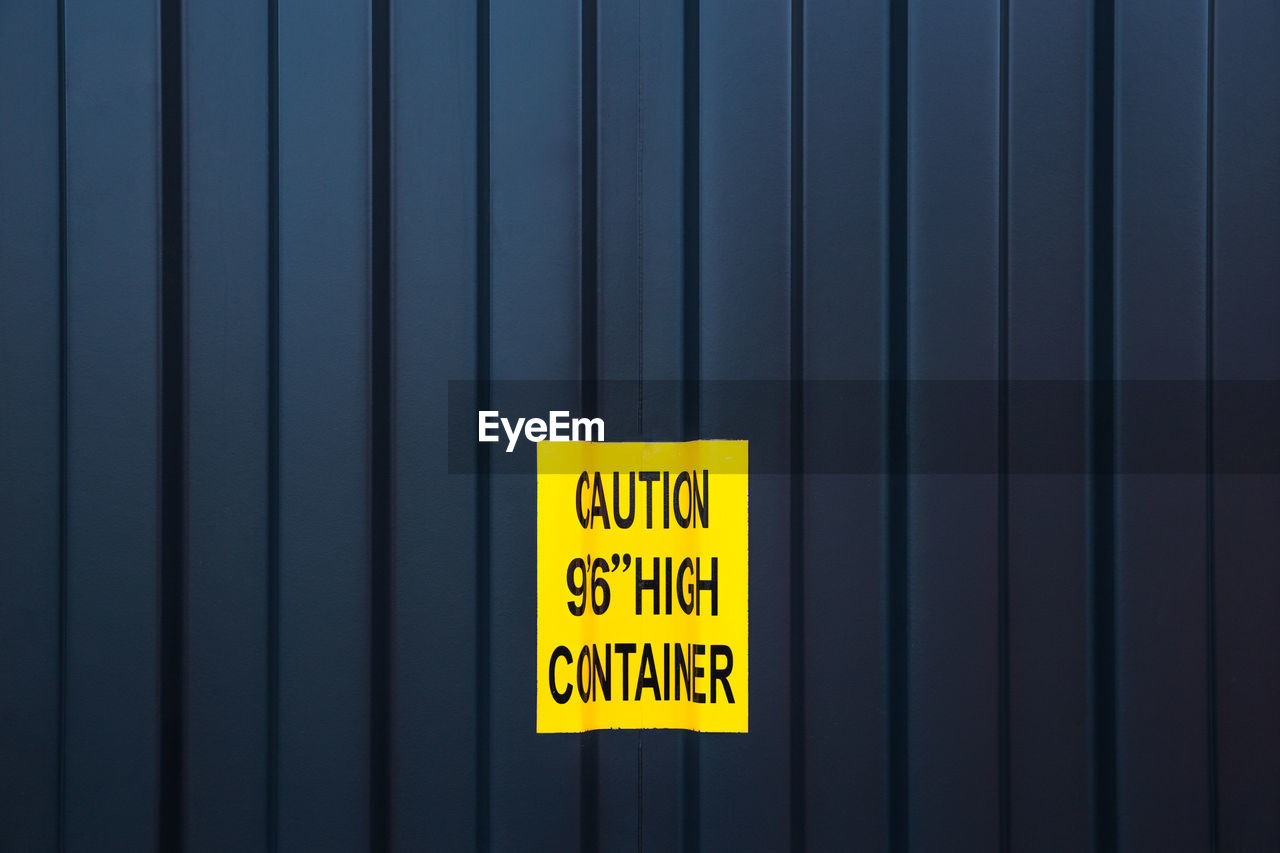 Close-up of yellow sign on cargo container