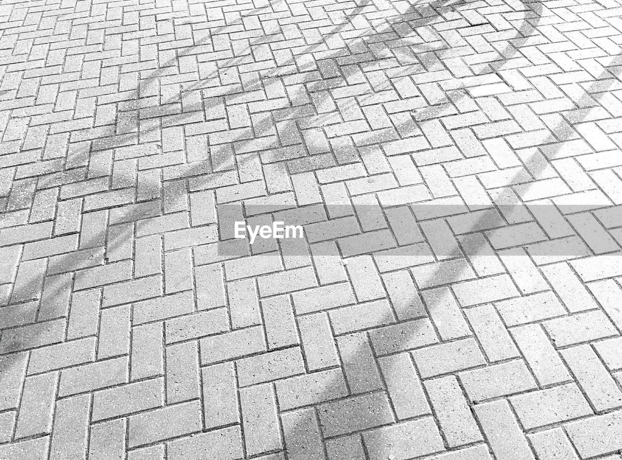 Shadow of bicycle on paving stone street