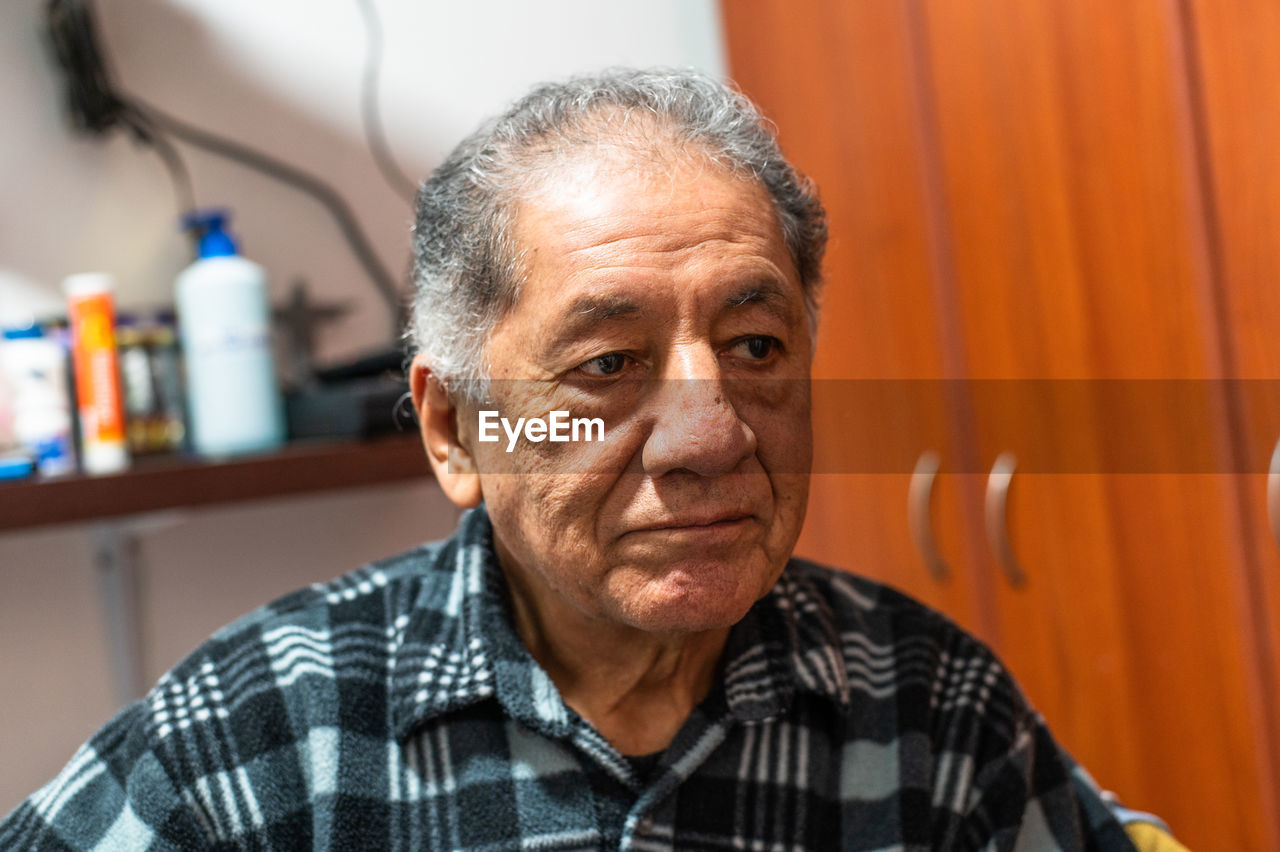 Portrait of happy senior man smiling at home