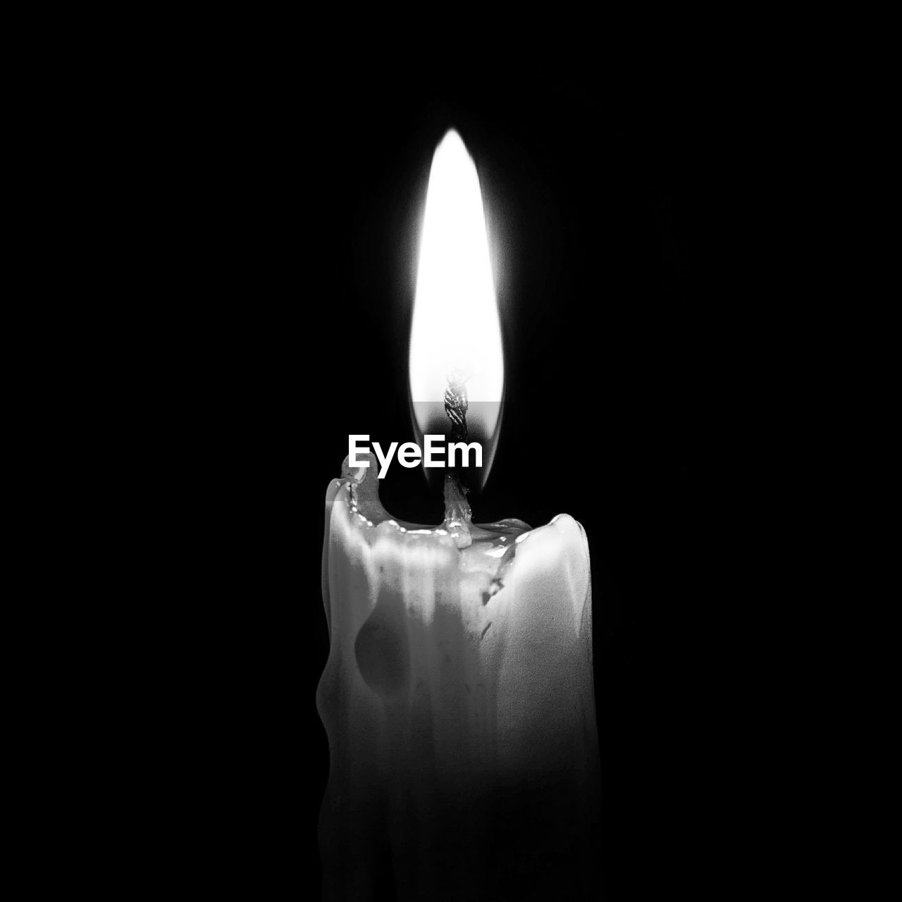 Lit candle against black background
