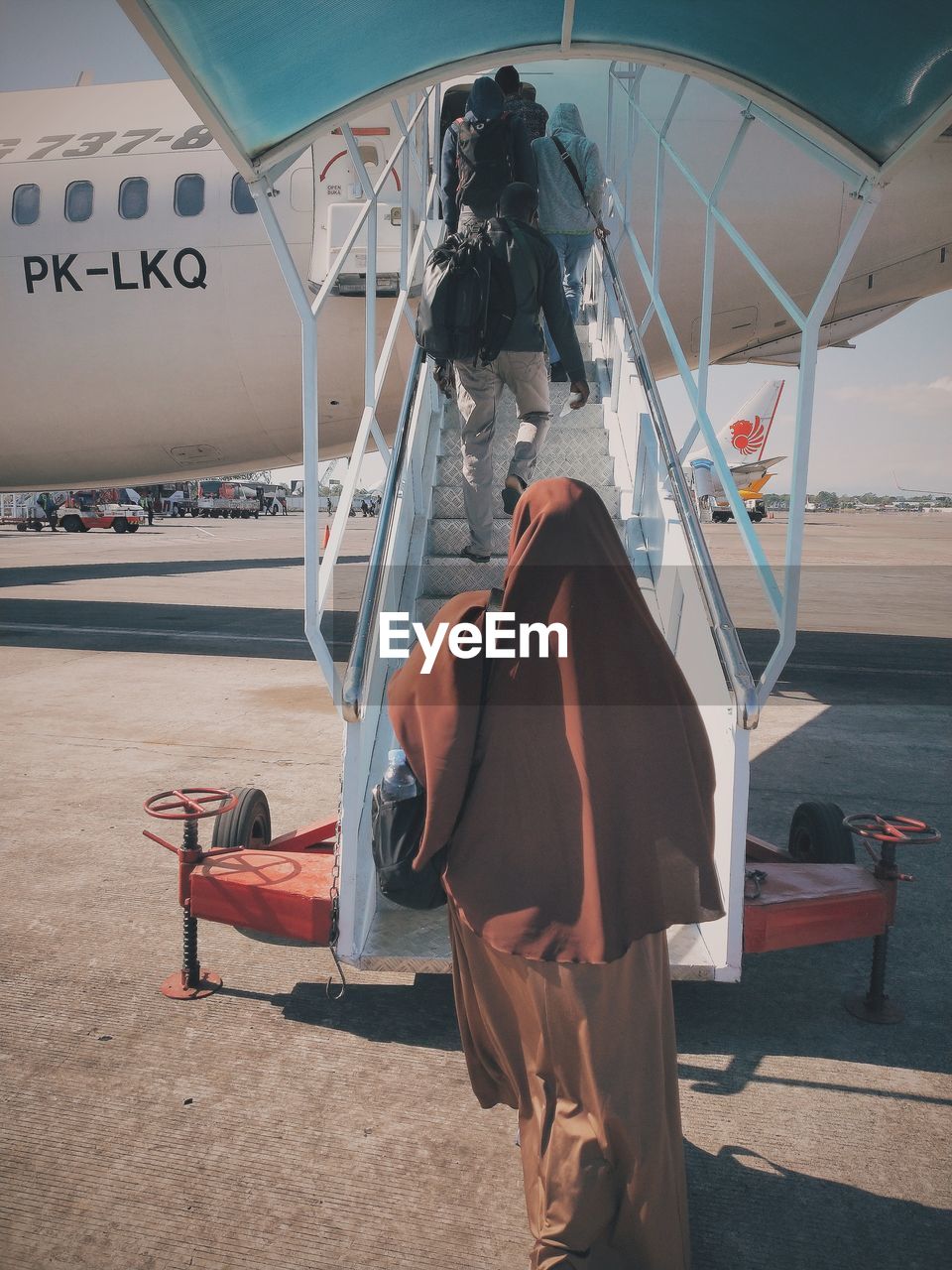 REAR VIEW OF MAN SITTING ON SEAT IN AIRPLANE