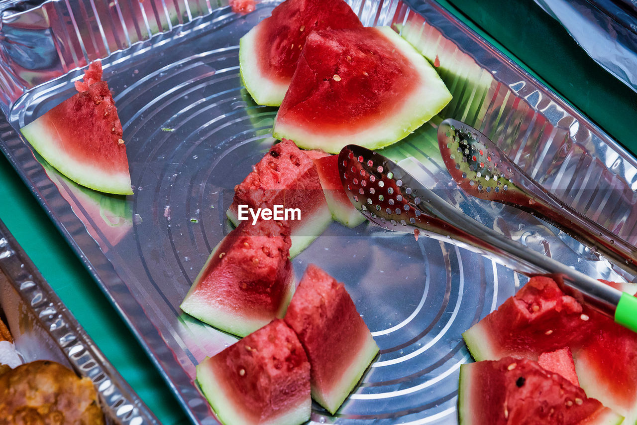 food and drink, food, watermelon, healthy eating, freshness, fruit, melon, plant, wellbeing, slice, produce, plate, fork, no people, high angle view, indoors, eating utensil, still life, red, kitchen utensil, dish, meal, close-up, table