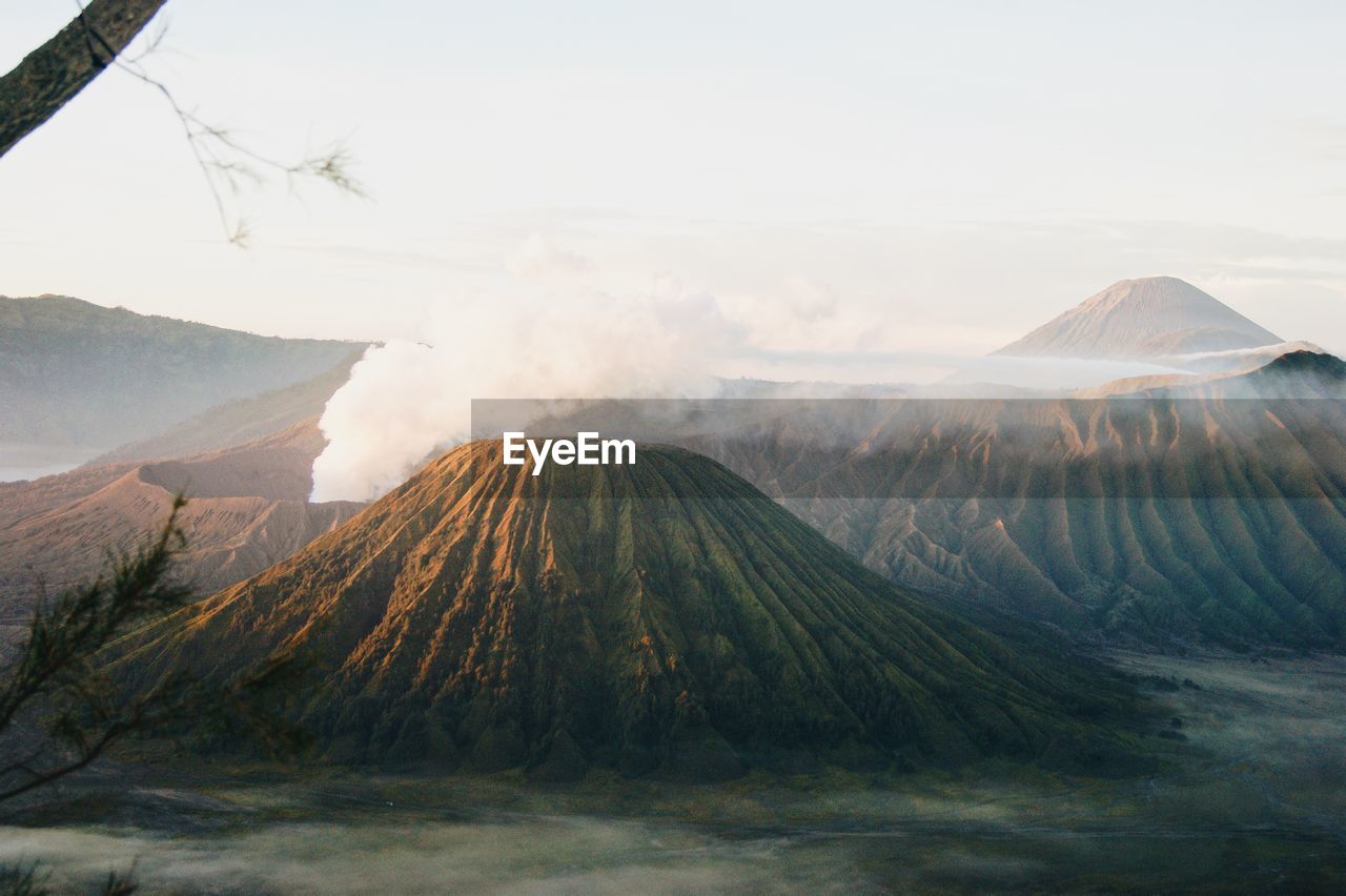 Smoke emitting from volcanic mountain against sky