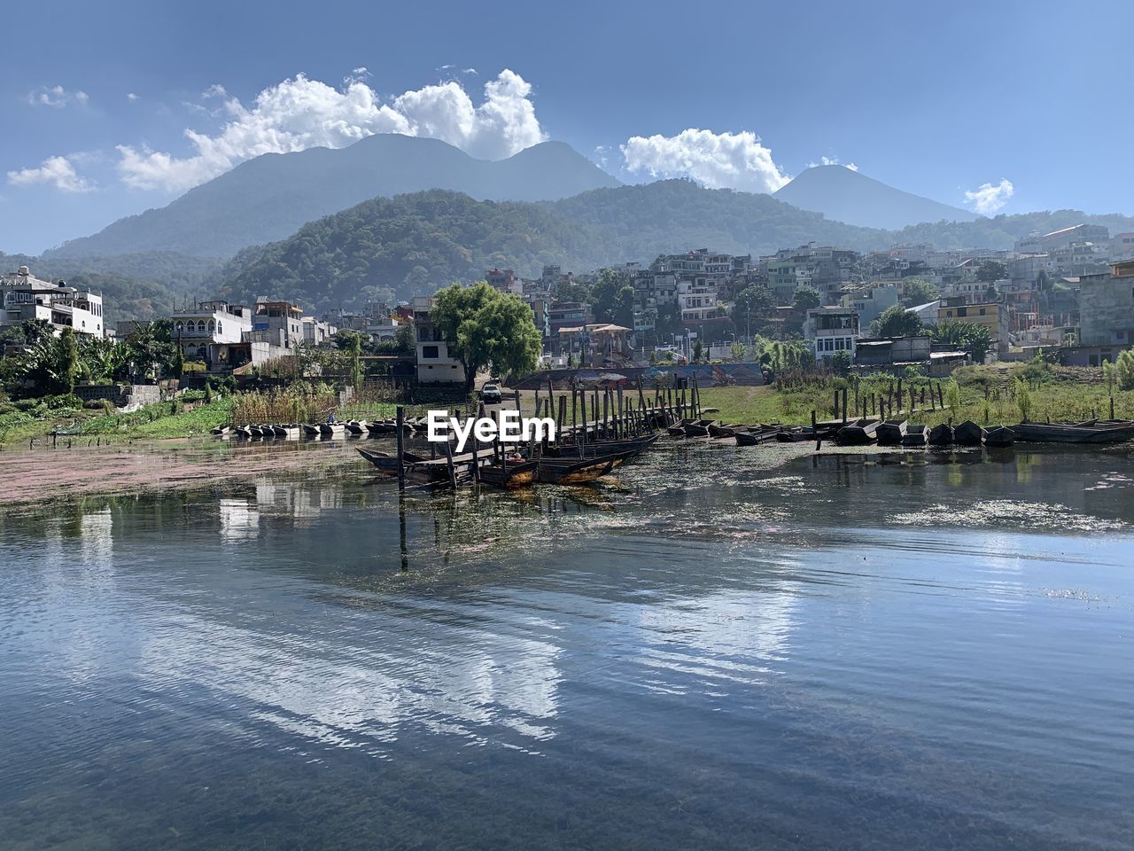 Scenic view of lake by buildings against sky