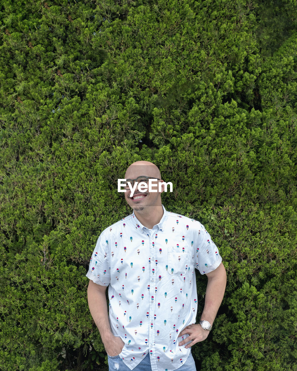 Portrait of young man standing by plants