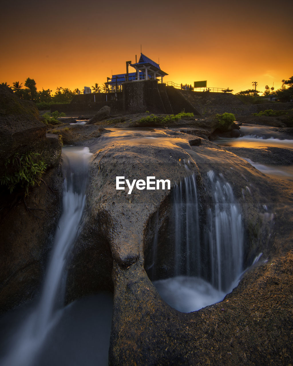 View of waterfall against sky during sunset