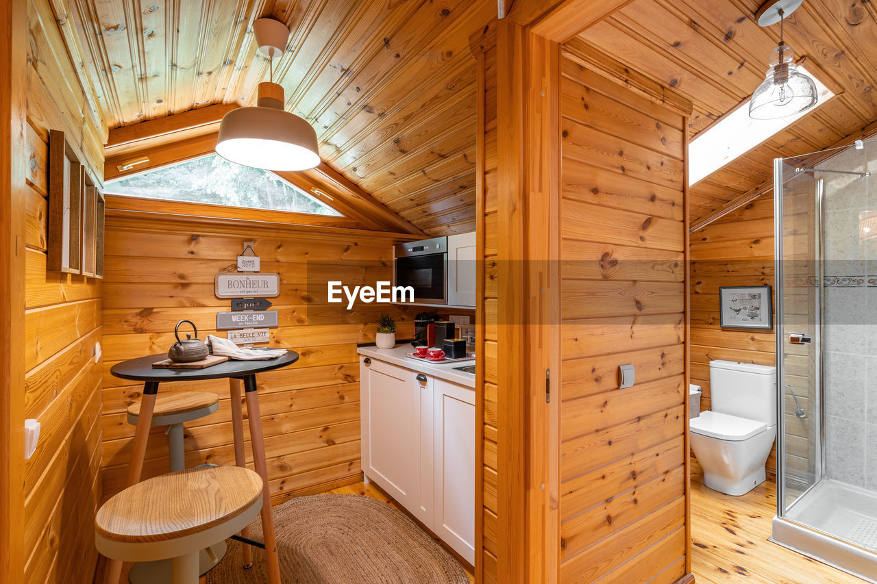 Compact kitchen with small bathroom in wooden house. village life concept.