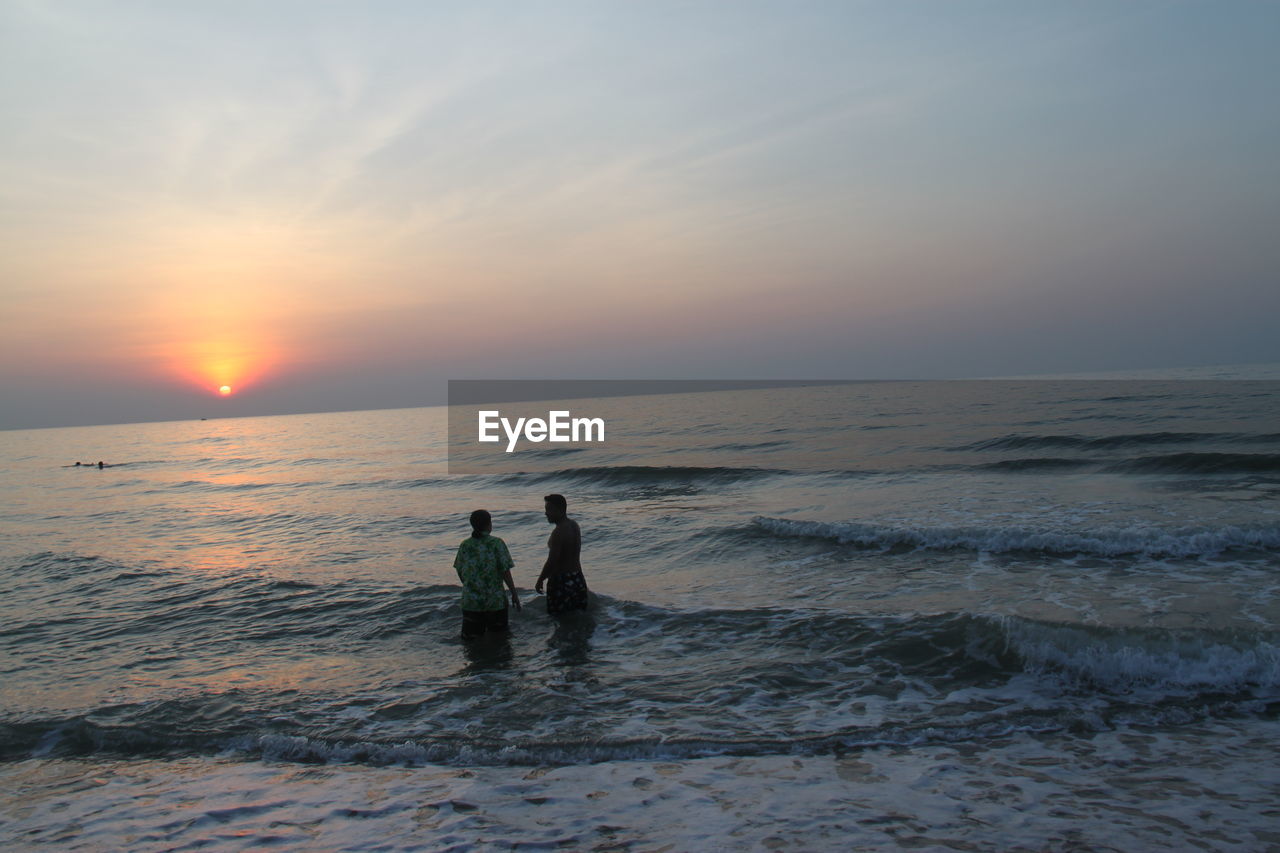 PEOPLE ON BEACH DURING SUNSET