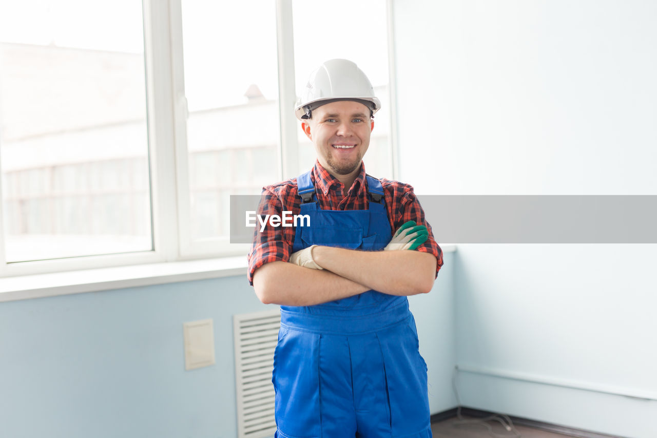 PORTRAIT OF SMILING MAN STANDING IN FRONT OF OFFICE