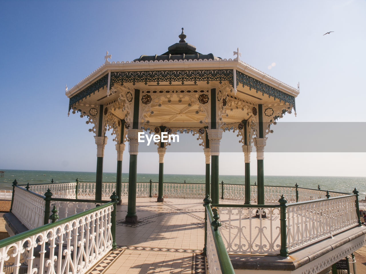 Empty gazebo at brighton pier by sea against clear sky on sunny day